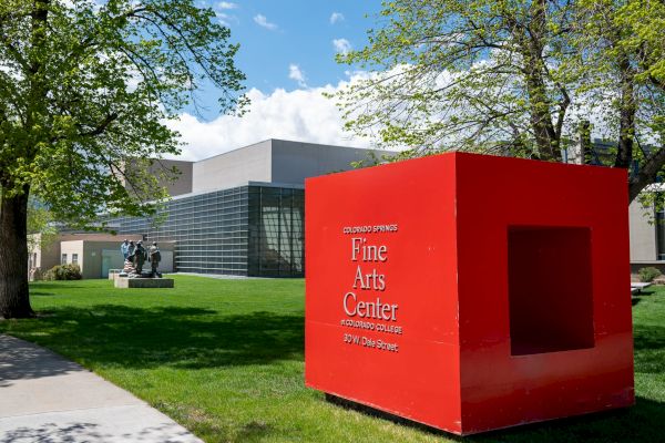 An outdoor scene with a red monument reading 
